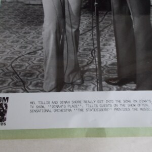 May include: Black and white photo of Mel Tillis and Dinah Shore singing together on Dinah's Place. The caption reads "Mel Tillis and Dinah Shore really get into the song on Dinah's network TV show, 'Dinah's Place'. Tillis is guests on the show often. Tillis Sensational Orchestra 'The Statesiders' provides the music."