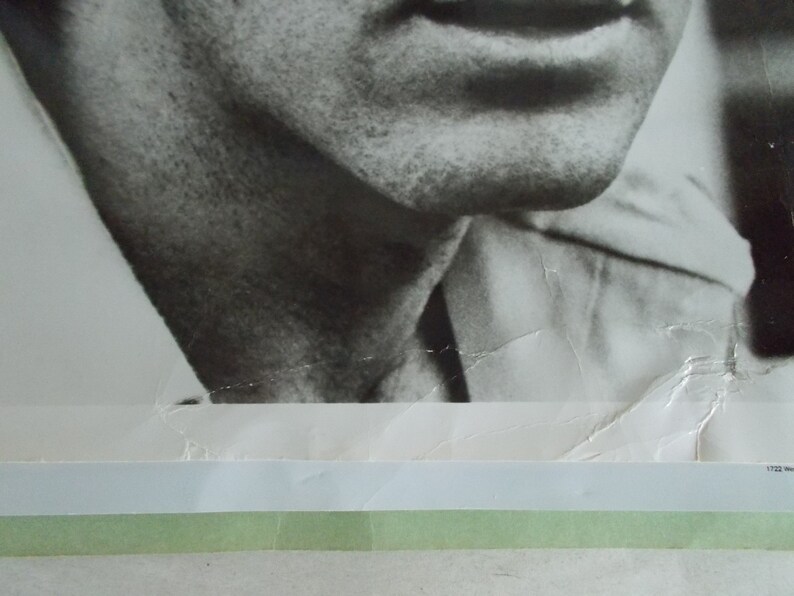 May include: Black and white photograph of a man's face and upper torso. The man is wearing a white shirt and has a serious expression on his face.
