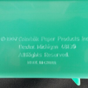 May include: A green plastic container with the text "1997 Colorbok Paper Products Inc. Dexter, Michigan 48130 All Rights Reserved. MADE IN CHINA" printed on the bottom.