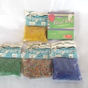 May include: A collection of craft supplies including four small plastic bags of colorful beads in green, gold, multi-color, and blue, each with a Dexter's Trimmings label, and one green box labeled Floral-Wrap Stemming Tape with a red rose graphic.