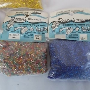 May include: Bags of Dexter's Trimmings, each with a label that reads "Decorate Your Own." The bags contain small, colorful beads. The labels are light blue and white, with illustrations of items to decorate.