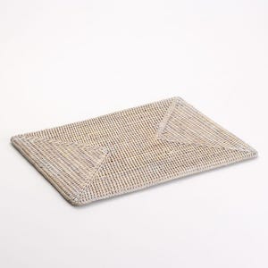 Könnte beinhalten: Ein rechteckiger, weißer geflochtener Platzdeckchen mit einem Rautenmuster.