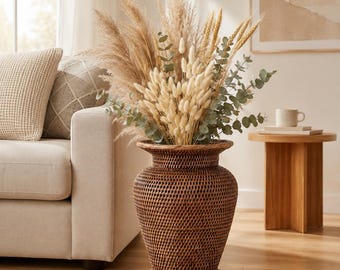 May include: A tall, dark brown woven rattan vase with a flared rim and base, filled with a large arrangement of dried pampas grass, fluffy white bunny tails, golden wheat stalks, and green eucalyptus branches in a natural, textured display.