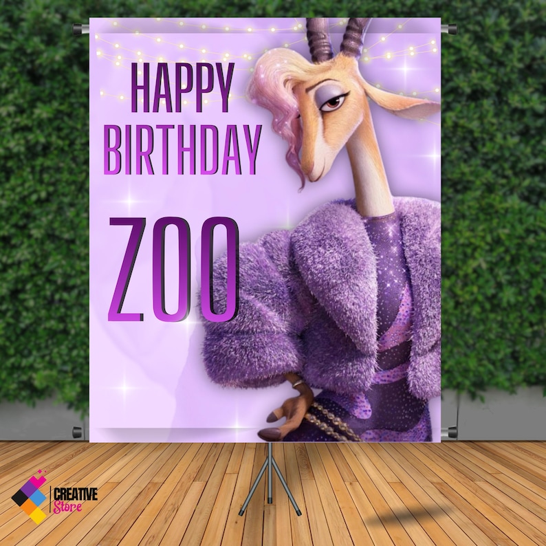 May include: A purple birthday banner with the text "HAPPY BIRTHDAY ZOO" and a cartoon gazelle character wearing a purple coat. The banner is supported by a tripod stand, with a green hedge background.