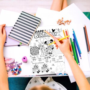 May include: Black and white coloring page featuring Mickey Mouse and Pluto. The page includes a maze, tic-tac-toe game, connect the dots, and find the differences activities. The text "Happy Birthday" is at the top of the page.