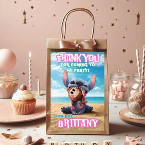 Puede incluir: Bolsa de regalo de papel marr&oacute;n con un personaje azul Stitch de Lilo & Stitch sosteniendo un juguete marr&oacute;n. La bolsa tiene una cinta rosa y una etiqueta de agradecimiento que dice "&iexcl;Gracias por venir a mi fiesta! Con cari&ntilde;o, Brittany".
