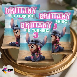 K&ouml;nnte beinhalten: Drei blaue und rosa Party-Geschenkt&uuml;ten mit einer Zeichentrickfigur Stitch, die eine Kokosnuss h&auml;lt. Die T&uuml;ten tragen den Text "Brittany wird 3 Jahre alt".