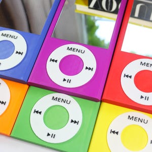 May include: A collection of six rectangular mirrors designed to resemble vintage digital music players. Each mirror features a colorful frame in blue, purple, red, orange, green, or yellow, with a white circular control interface printed with MENU.