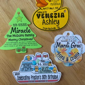 May include: Four custom-shaped tags featuring printed text and graphics. One is a green Christmas tree, one is a yellow duck, one is a white cloud shape with ducks, and one is a white cruise ship. Each tag includes a hole for hanging and personalized text.