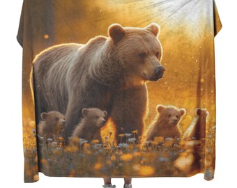 Una osa grizzly y sus crías caminan en un prado resplandeciente de flores silvestres doradas bajo una suave manta polar sherpa naranja con efecto amanecer.