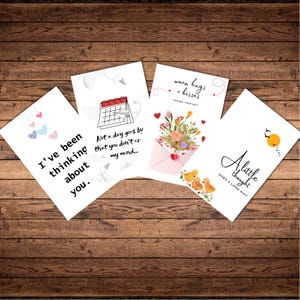 May include: Four white greeting cards with various designs and text on a wooden background. The cards feature phrases like "I've been thinking about you," and "A little thought goes a long way." One card has a calendar illustration.