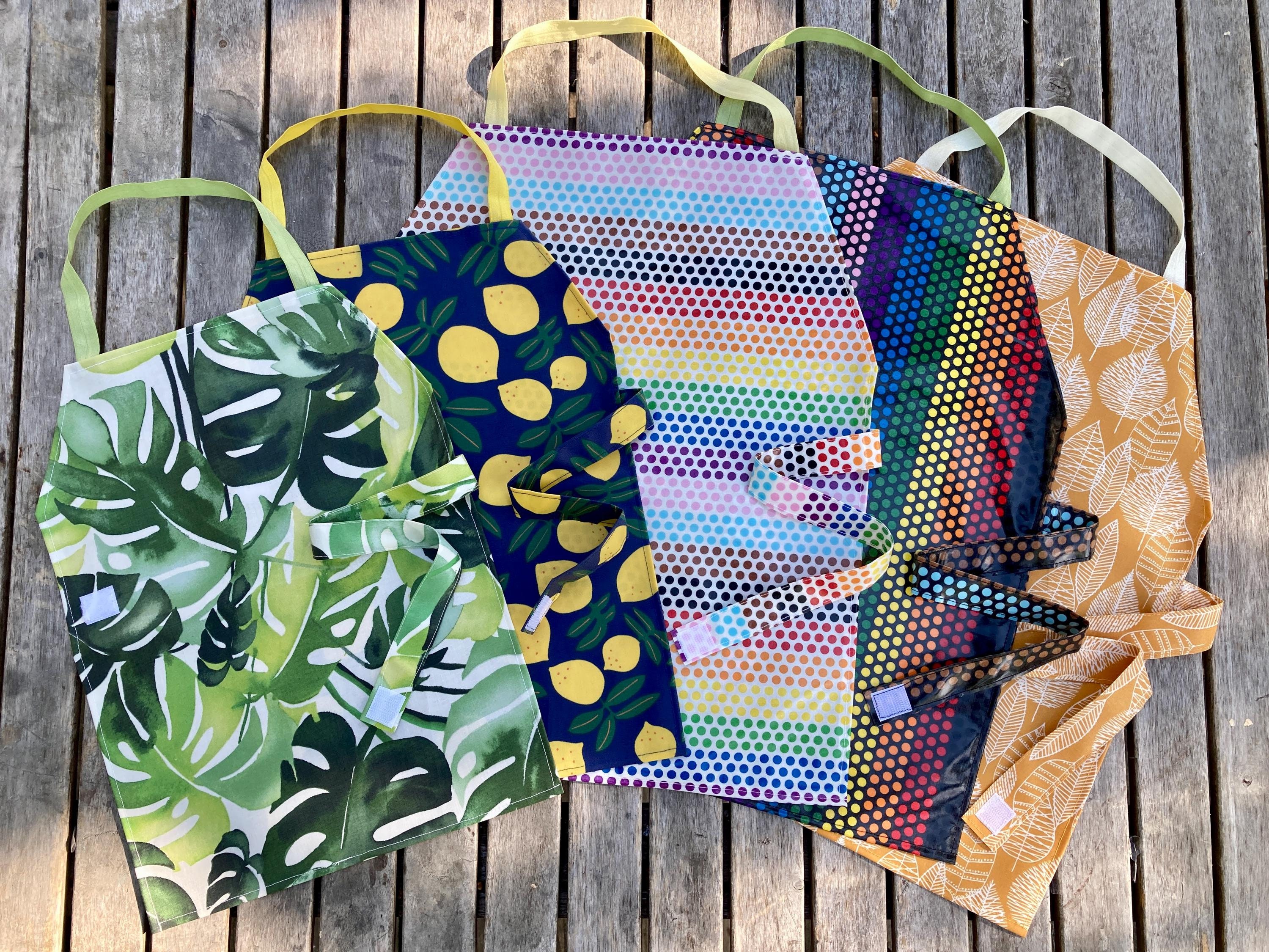 Waterproof Aprons & Mats - Toddler, Primary, and Elementary Sizes, Monstera, Rainbow Dots, Lemons, and Golden Leaves, Elastic Neck Band