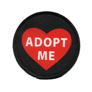 May include: A black and red round patch with a red heart that says "ADOPT ME" in white text.