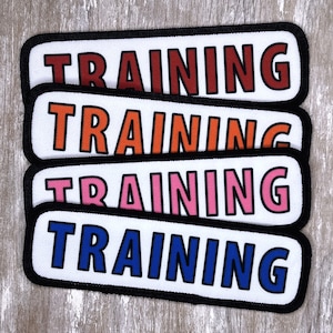 May include: Four white patches with black borders, each with the word "TRAINING" in a different color: red, orange, pink, and blue.