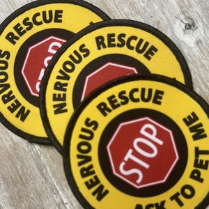 May include: Three yellow and black round patches with the text "NERVOUS RESCUE" and a red stop sign with the word "STOP" in white. The bottom patch also has the text "ASK TO PET ME".