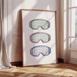 Könnte beinhalten: Drei Paar Skibrillen mit verschiedenen Farben für Rahmen und Gläser. Die Gläser sind mit einem sich wiederholenden Muster von Martini-Gläsern verziert.