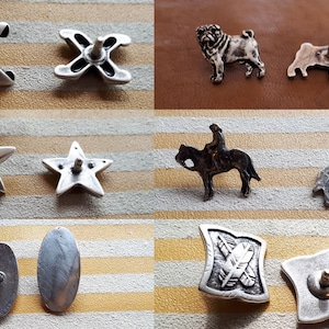 May include: A collection of ten silver-toned metal conchos, featuring various designs including a star, a cross, a pug dog, a horse, and a feather. These conchos are perfect for adding a touch of western style to your leather goods.