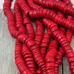 May include: A strand of bright red coral beads. The beads are round and have a slightly textured surface.