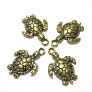May include: Four bronze turtle charms with detailed shell patterns and jump rings. These small pendants are suitable for jewellery making or craft projects. The turtles are arranged against a white background.