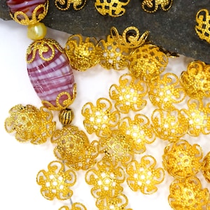 May include: A white ceramic mug with a black handle and the text "But First, Coffee" in a bold, black font. The mug is set against a blurred background, suggesting a cozy setting.