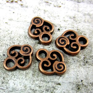 Puede incluir: Cuatro abalorios de metal de color cobre con un dise&ntilde;o de nudo celta en espiral. Cada abalorio tiene un di&aacute;metro de aproximadamente 2,5 cm.