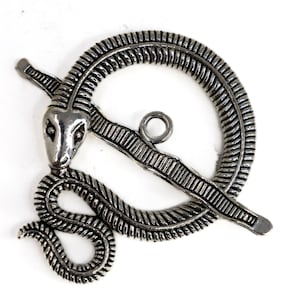 May include: A silver-coloured metal brooch with a stylised snake design. The brooch has a circular frame with a snake head and body forming the clasp. The snake's body wraps around the frame, creating a unique and detailed accessory.