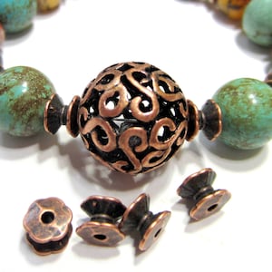 Puede incluir: Un brazalete de cobre con cuentas turquesa y marrones, una cuenta grande de cobre filigrana y cuatro cuentas de cobre más pequeñas.