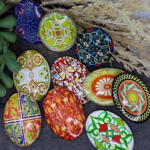 May include: Nine colorful ceramic tiles with intricate geometric patterns. The tiles are oval shaped and feature a variety of colors, including blue, green, red, yellow, and white.