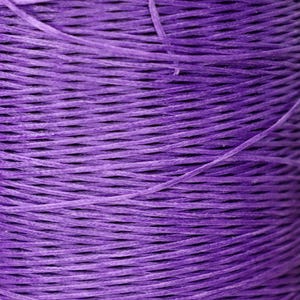 May include: Close-up of a spool of purple cord. The cord is tightly wound and has a smooth, even texture.