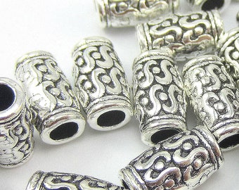 Peut inclure: Des embouts de perles en métal argenté avec un design complexe et orné. Les embouts sont cylindriques et ont une finition lisse et polie.