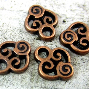 Puede incluir: Cuatro abalorios de metal de color cobre con un dise&ntilde;o de nudo celta en espiral. Cada abalorio tiene un di&aacute;metro de aproximadamente 2,5 cm.