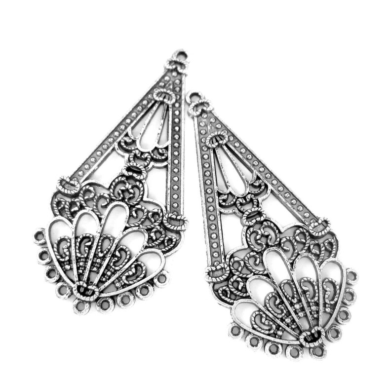 Peut inclure: Deux composants de boucles d'oreilles en filigrane argent&eacute;. Chaque composant est en forme de goutte d'eau avec des motifs ajour&eacute;s complexes. Les composants ont une s&eacute;rie de petits trous le long du bord inf&eacute;rieur et une boucle en haut.