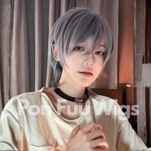 May include: A person wearing a light grey wig with a short, layered style. The person is wearing a white t-shirt and a black choker necklace. The text "Pon Fu Wigs" is visible on the shirt.