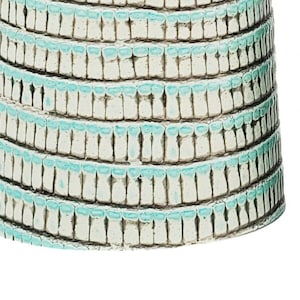 May include: Two leather bracelets with a light blue and white patterned design. One bracelet has two gold-toned metal buttons.