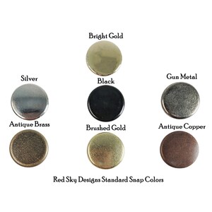 K&ouml;nnte beinhalten: Eine Auswahl von acht verschiedenen farbigen Metall-Druckkn&ouml;pfen, darunter gl&auml;nzendes Gold, Silber,  Metallgrau, Schwarz, Antik-Messing, geb&uuml;rstetes Gold und Antik-Kupfer. Der Text "Red Sky Designs Standard Snap Colors" ist unter den Druckkn&ouml;pfen gedruckt.