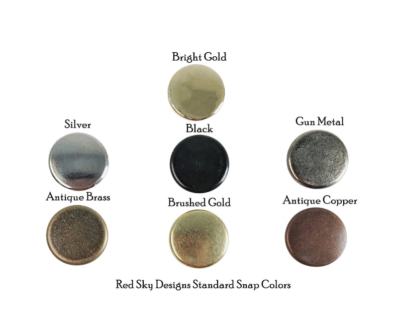 K&ouml;nnte beinhalten: Eine Auswahl von acht verschiedenen farbigen Metall-Druckkn&ouml;pfen, darunter gl&auml;nzendes Gold, Silber,  Metallgrau, Schwarz, Antik-Messing, geb&uuml;rstetes Gold und Antik-Kupfer. Der Text "Red Sky Designs Standard Snap Colors" ist unter den Druckkn&ouml;pfen gedruckt.