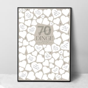 May include: A framed print with a beige background and numerous white heart shapes. The print features German text, including the number "70" and the words "Dinge die wir dir w&uuml;nschen," which translates to "70 things we wish you."