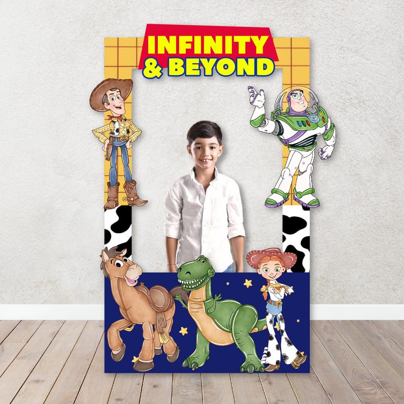 Puede incluir: Un accesorio de cabina de fotos de cart&oacute;n con personajes de la franquicia Toy Story. Los personajes incluyen a Woody, Buzz Lightyear, Jessie, Rex y un dinosaurio. El accesorio tiene un fondo azul con estrellas y el texto "Infinity & Beyond".