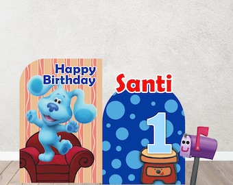May include: Two-piece birthday decoration featuring Blue from Blue's Clues. One piece has the text "Happy Birthday" and Blue on a red chair. The other piece has the name "Santi" and the number "1". A purple mailbox is also included.
