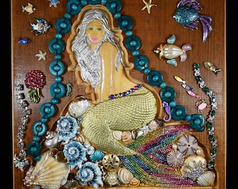 Sirena in casa, opera d'arte con gioielli incorniciata, insolita combinazione di intaglio del legno, gioielli e conchiglie. 28 x 29 cm