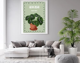 May include: A framed botanical print featuring an Alocasia plant in a terracotta pot. The print has a light green background with the word "ALOCASIA" and "BLACK VELVET" in white text. The image is displayed in a modern living room setting.