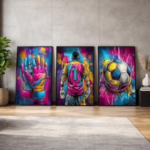 May include: A triptych of framed art prints with colourful, abstract soccer-themed designs. The prints show goalie gloves, a soccer player from behind, and a soccer ball, all in a graffiti-style. The artwork uses a vibrant palette of pinks, blues, and yellows.