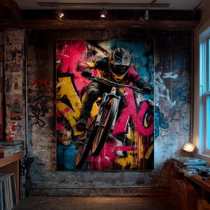 May include: A striking artwork showcases a mountain biker mid-air against a graffiti-style backdrop. The rider, wearing protective gear, is the focal point. The artwork uses bold colours such as pink, yellow, and blue, creating a dynamic and energetic scene.