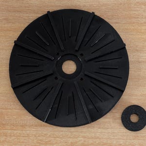 May include: A black rubber disc with a central hole and radiating spokes. A smaller black rubber disc with a central hole is also shown.