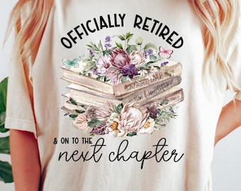 May include: A white t-shirt with the text "Officially Retired & On To The Next Chapter" printed on it. The text is surrounded by a floral design with books and butterflies.