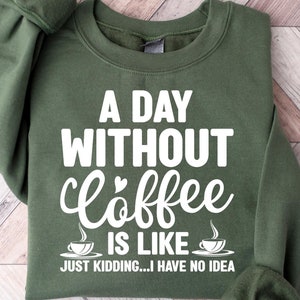 May include: A green sweatshirt with the text "A Day Without Coffee Is Like... Just Kidding... I Have No Idea" in white. The text is stylized with a coffee cup graphic and a heart.