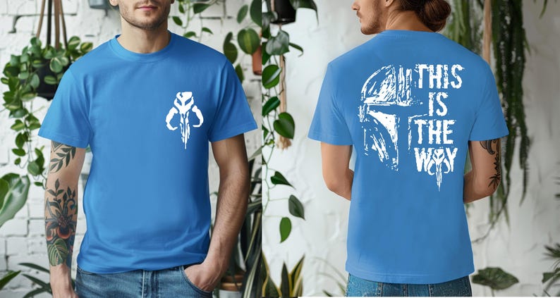 May include: A blue t-shirt with a white graphic of a skull-like symbol on the front and a helmet design with the text "THIS IS THE WAY" on the back. The shirt is short-sleeved and made of a soft material.