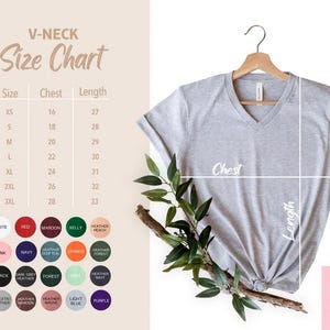 May include: A light gray V-neck t-shirt hanging on a wooden hanger. The image includes a size chart with chest and length measurements in inches, and a color chart with various options.