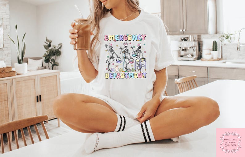 May include: White t-shirt with a graphic of three skeletons holding Easter baskets and the text "Emergency  Easter Department".