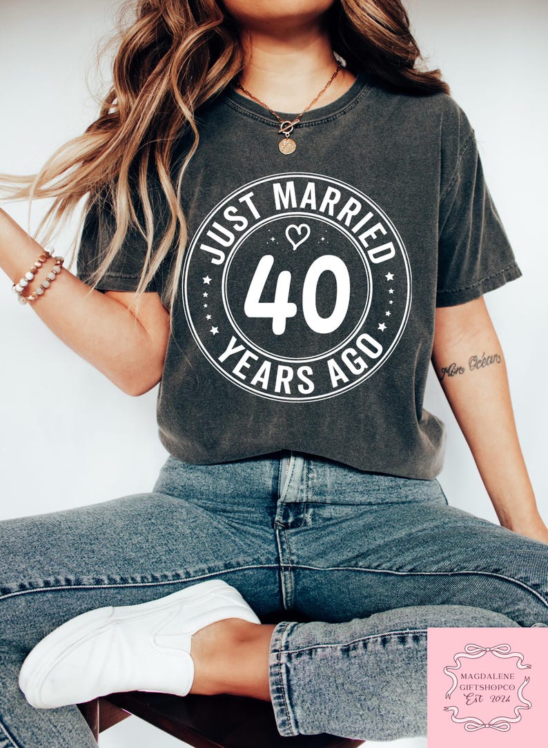May include: A gray t-shirt with a white circle graphic that says "Just Married 40 Years Ago" with a heart symbol.